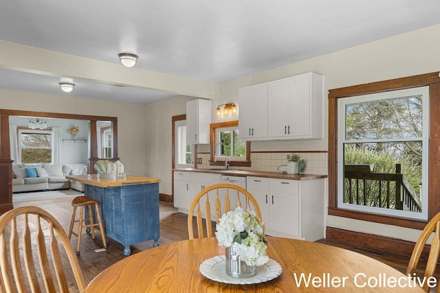 kitchen with white cabinets, butcher block countertops, and a wealth of natural light