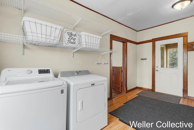 laundry area featuring light wood-style floors, baseboards, laundry area, and washer and dryer