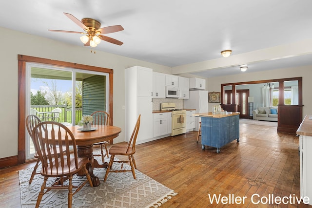 dining space featuring baseboards, ceiling fan, and hardwood / wood-style floors