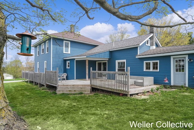 back of property with a lawn, a chimney, and a wooden deck