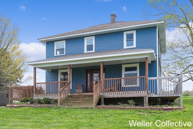 view of front of house with a shingled roof, a front yard, a chimney, and covered porch
