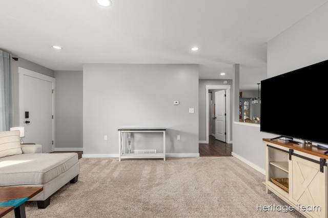 carpeted living area with baseboards and recessed lighting