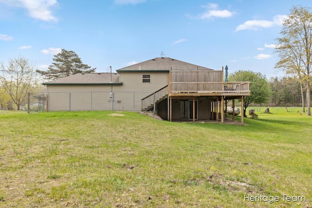 rear view of house featuring a lawn, fence, a wooden deck, and stairs