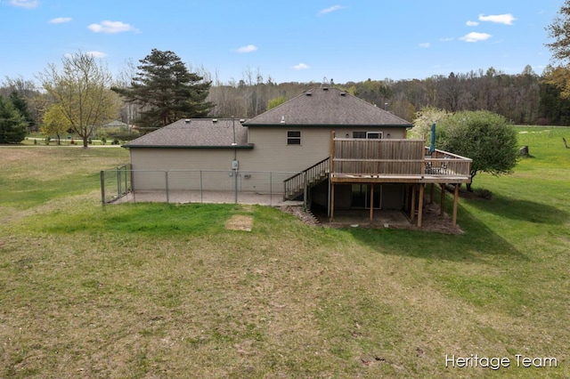 back of property with a yard, fence, a wooden deck, and stairs