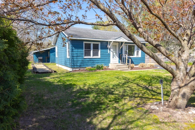 view of front of house featuring roof with shingles and a front lawn