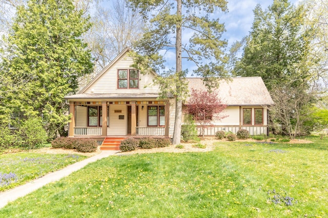 view of front of house with a shingled roof, a porch, and a front lawn