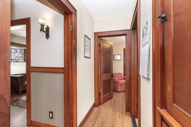 hallway with light wood-style floors and baseboards