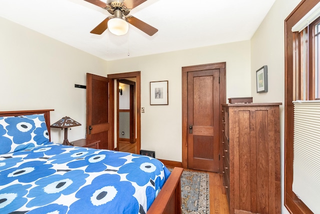 bedroom featuring baseboards, a ceiling fan, and wood finished floors