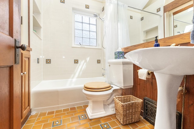 full bath featuring toilet, tile patterned flooring, and shower / tub combo with curtain