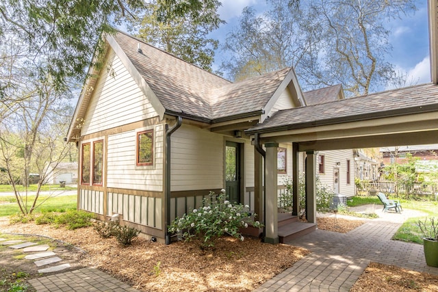 view of side of home featuring roof with shingles