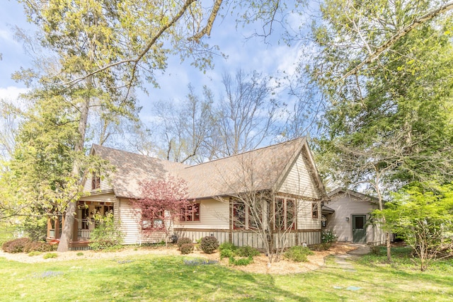 view of side of property with a lawn and a shingled roof