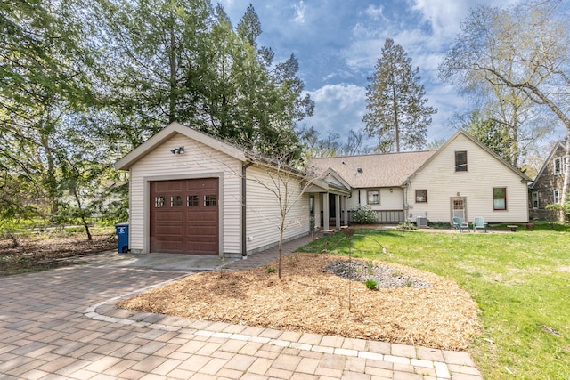 view of front facade with a garage, driveway, cooling unit, and a front lawn