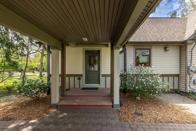 property entrance featuring roof with shingles