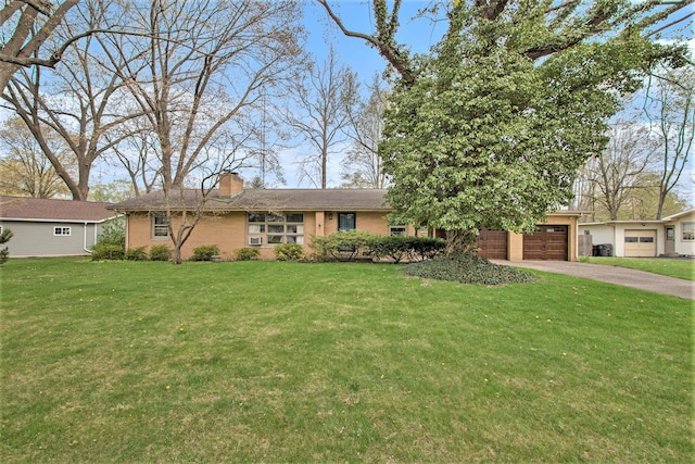 ranch-style home featuring brick siding, driveway, a chimney, and a front lawn