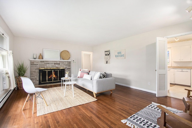 living room featuring baseboards, a fireplace, a baseboard heating unit, and wood finished floors