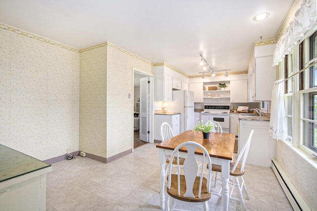 dining room featuring light tile patterned floors, rail lighting, wallpapered walls, and baseboard heating