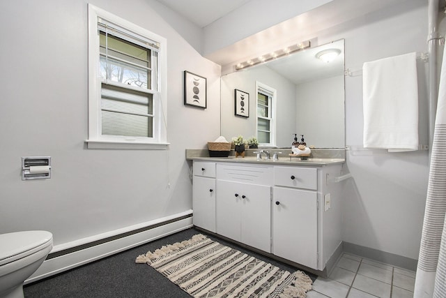 bathroom featuring tile patterned flooring, baseboard heating, baseboards, vanity, and toilet