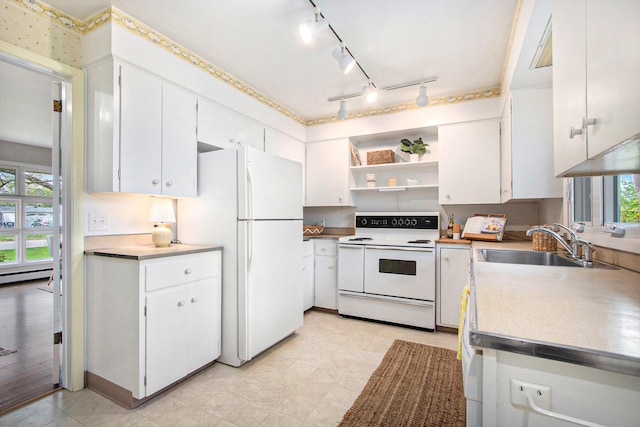 kitchen with white appliances, white cabinets, a wealth of natural light, and a sink