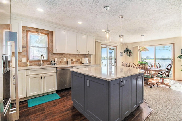 kitchen with a sink, white cabinets, dishwasher, and a healthy amount of sunlight