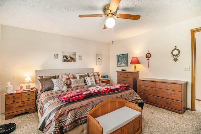 bedroom featuring light colored carpet, a ceiling fan, and a textured ceiling