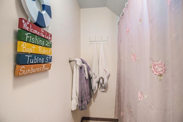 bathroom featuring a textured ceiling and lofted ceiling