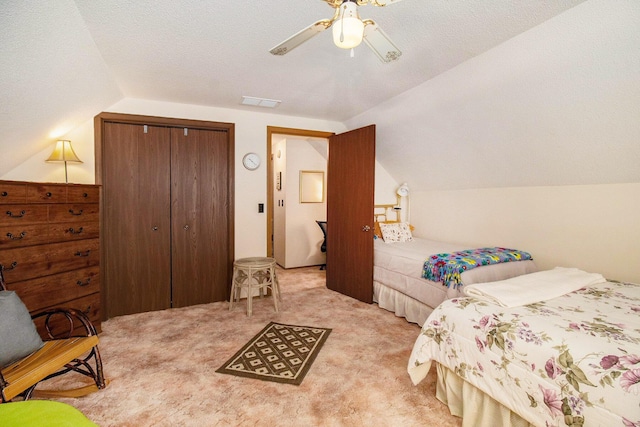 bedroom featuring visible vents, a closet, lofted ceiling, and light carpet