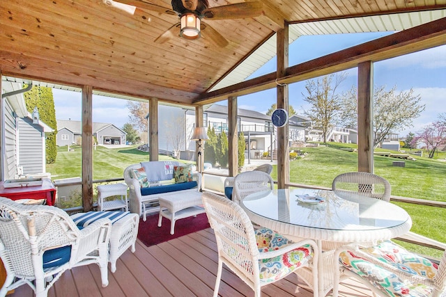 sunroom featuring a residential view, a ceiling fan, and a healthy amount of sunlight