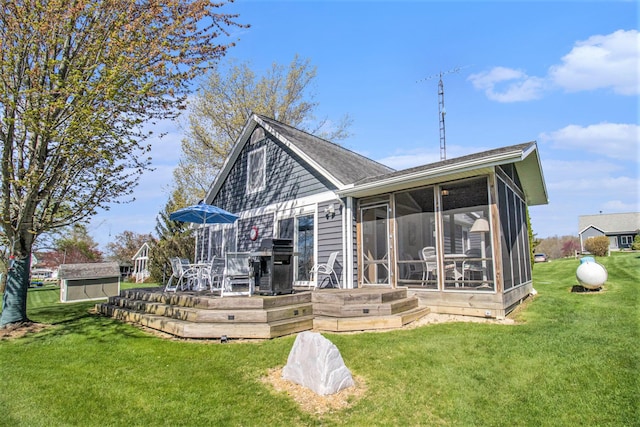 rear view of property with a yard and a sunroom