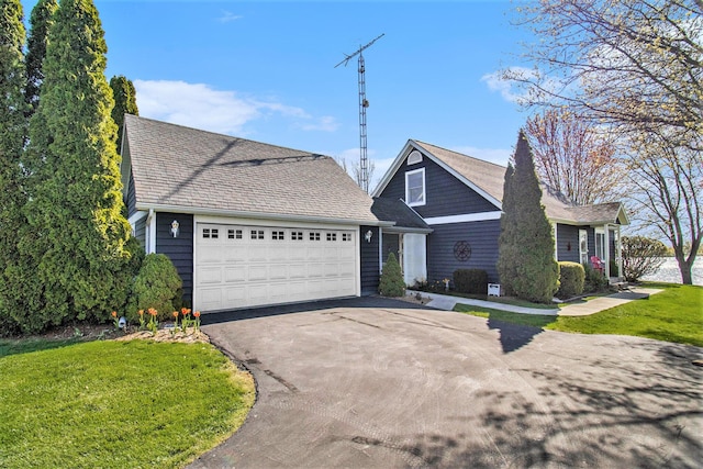 view of front of property with a garage, driveway, a shingled roof, and a front lawn