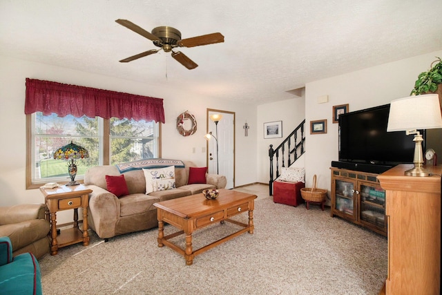 living room with light colored carpet, stairs, and ceiling fan