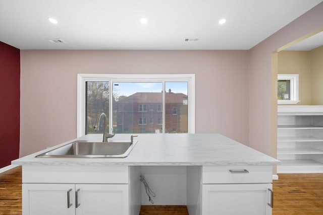 1989 Gladstone St, Detroit, MI 48206 - kitchen with a healthy amount of sunlight, a sink, white cabinets, recessed lighting, and light wood-style flooring