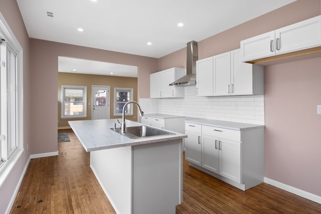 1989 Gladstone St, Detroit, MI 48206 - kitchen featuring wall chimney range hood, a sink, dark wood finished floors, white cabinetry, and tasteful backsplash