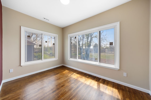 1989 Gladstone St, Detroit, MI 48206 - unfurnished room with baseboards, visible vents, and dark wood-style floors