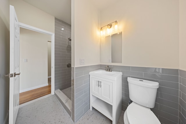 1989 Gladstone St, Detroit, MI 48206 - full bathroom featuring tile walls, wainscoting, vanity, toilet, and tiled shower