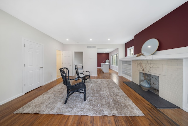 1989 Gladstone St, Detroit, MI 48206 - living room with visible vents, baseboards, a brick fireplace, and wood finished floors