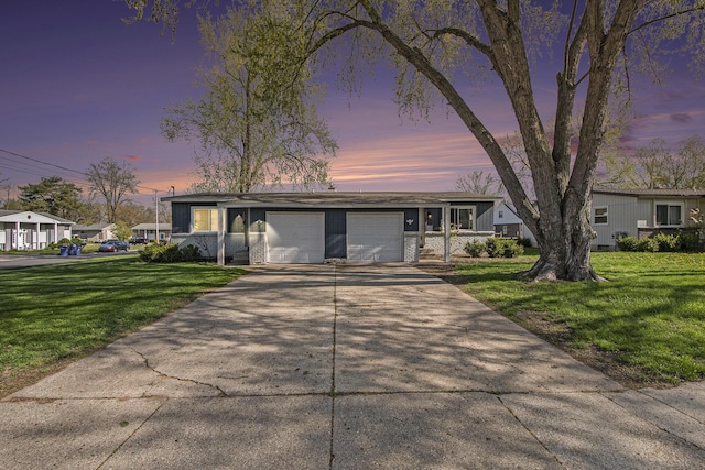 view of front facade with concrete driveway, an attached garage, and a front yard