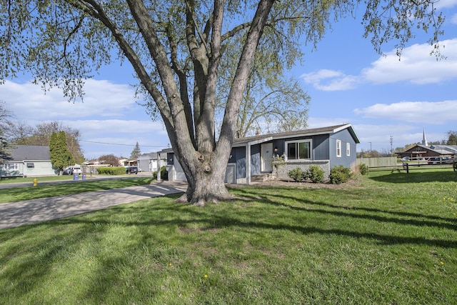 view of front of home featuring a garage, fence, driveway, and a front yard