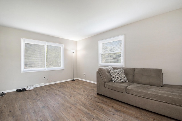 living room featuring baseboards, wood finished floors, and visible vents