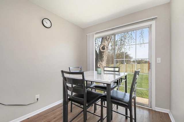 dining area with baseboards and wood finished floors