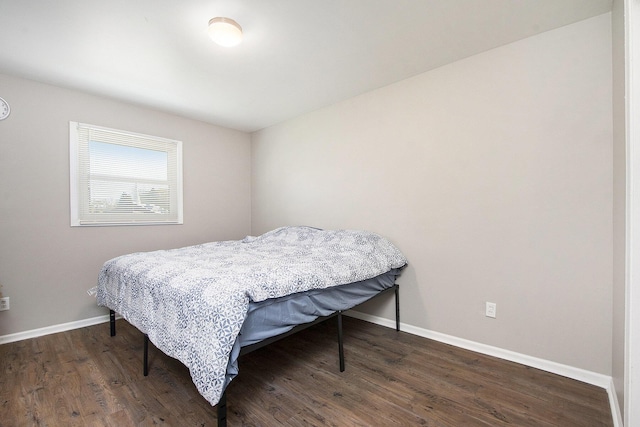 bedroom with baseboards and wood finished floors