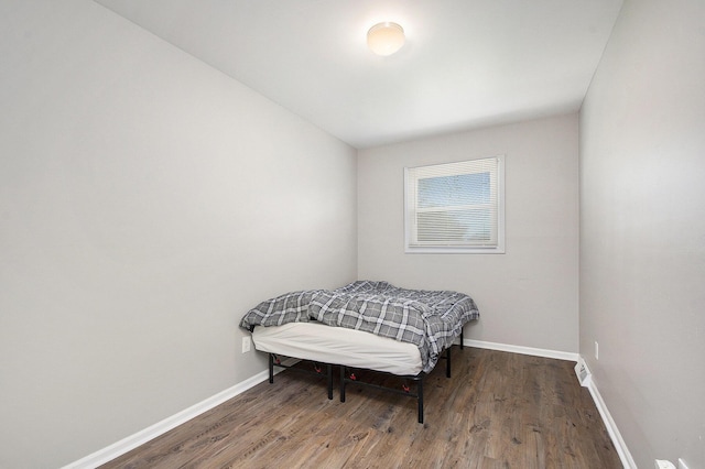 bedroom with baseboards and wood finished floors