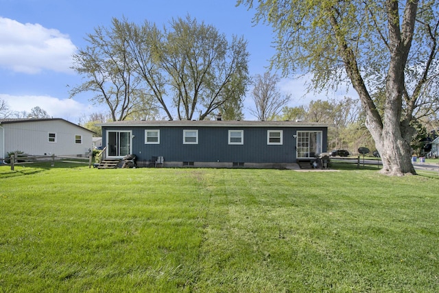 back of property with a yard, fence, and entry steps