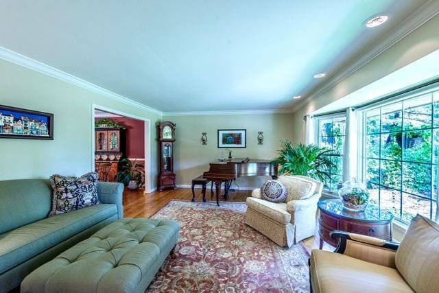 living room with recessed lighting, ornamental molding, baseboards, and wood finished floors