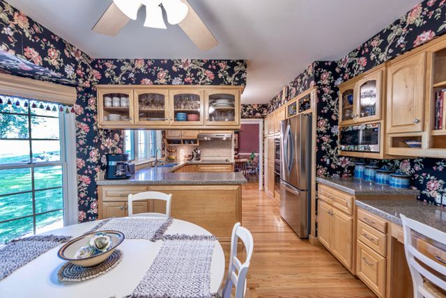 kitchen with light wood-style floors, plenty of natural light, stainless steel appliances, and wallpapered walls