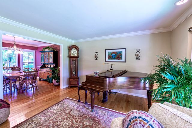 interior space featuring baseboards, ornamental molding, wood finished floors, and a chandelier