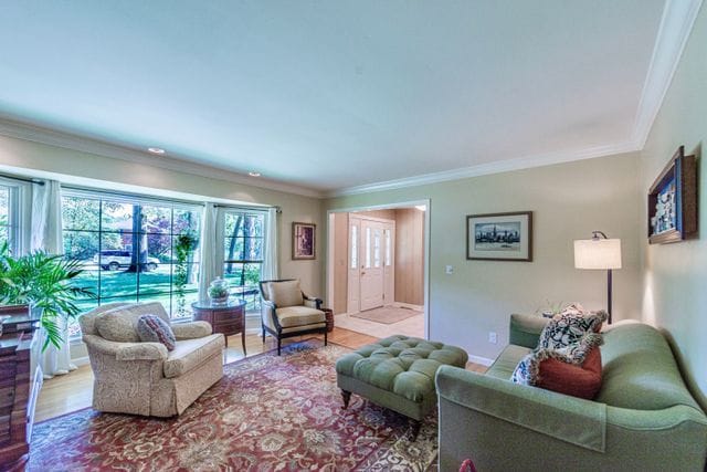 living area featuring crown molding and wood finished floors
