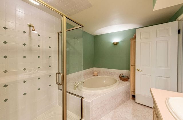 full bath with vanity, a stall shower, a bath, and tile patterned flooring