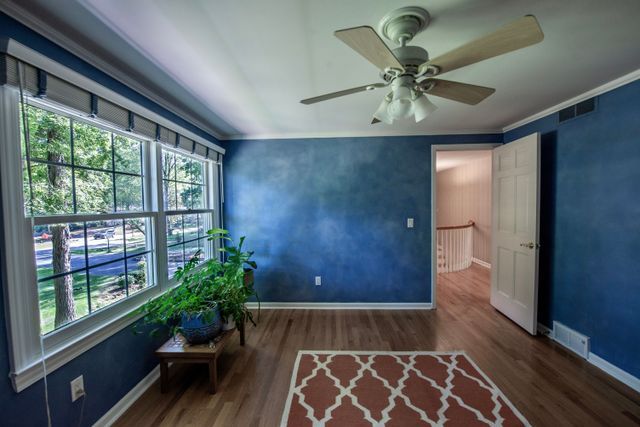 interior space featuring a ceiling fan, baseboards, a wealth of natural light, and wood finished floors