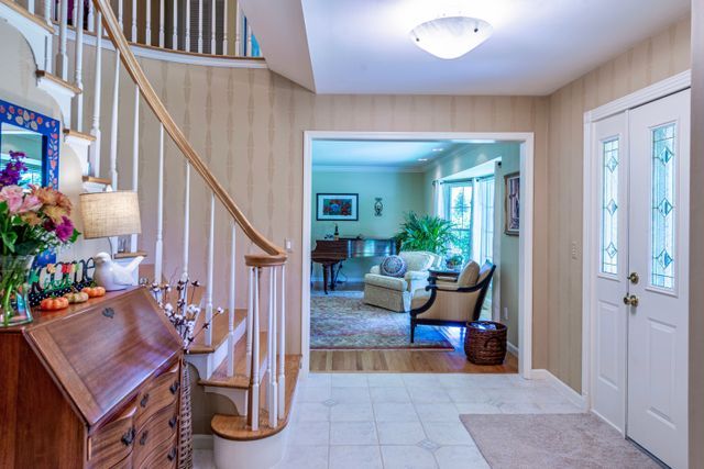 foyer with stairway, tile patterned floors, and baseboards