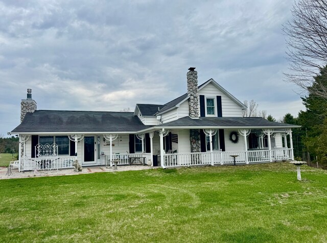 3121 Grace Rd, Frankfort, MI 49635 - farmhouse-style home featuring a chimney, covered porch, and a front yard